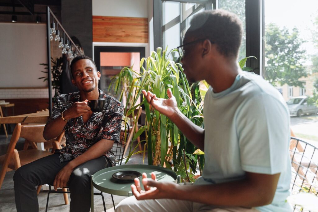 Two men in an engaged, genuine conversation over coffee.